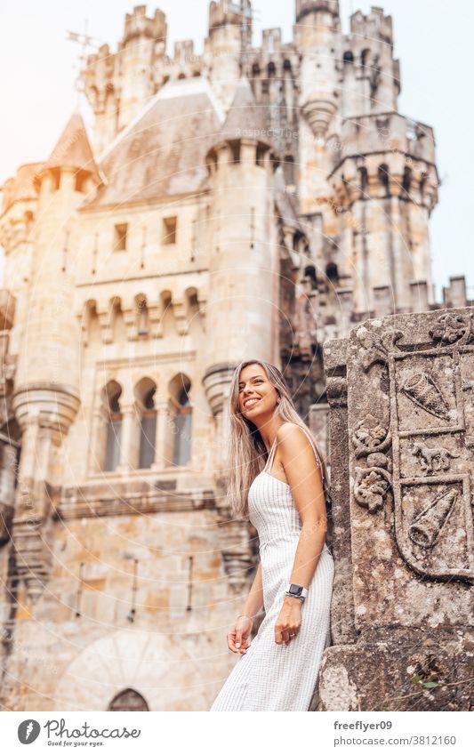 Young woman in front of a medieval castle tourist blonde young 20s tourism travel posing butron leaning basque country spain hiking princess copy space vizcaya