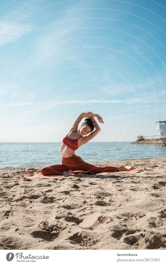 Young adult female in Pigeon pose on a beach in the morning yogini pretty mat mind nature practicing hamstring sea Hip opener Eka Pada Rajakapotasana
