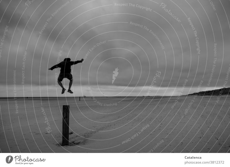 Man jumps from a post on the beach. black-white daylight Day lake nordesee coast Beach Sand Nature Horizon Landscape Water Ocean Sky Black White