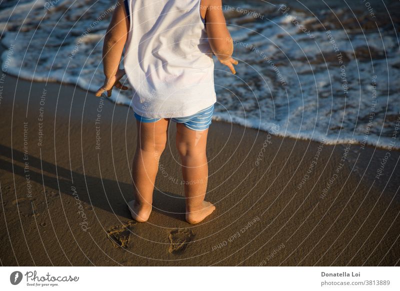 barefoot child by the sea 2-3 years alone beach childhood cose up details feet fingerprint little boy lonely shadow summer summer dress sunny sunset water waves