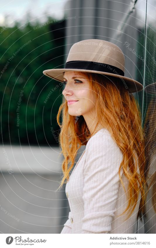 Charming red haired woman in hat standing on street redhead style smile trendy urban modern positive young female fashion long hair lady confident charming