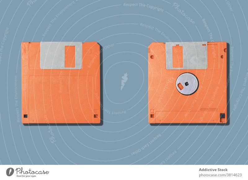 Computer floppy disks on gray background two old diskette computer pc old fashioned information data obsolete orange equipment device tool vintage retro