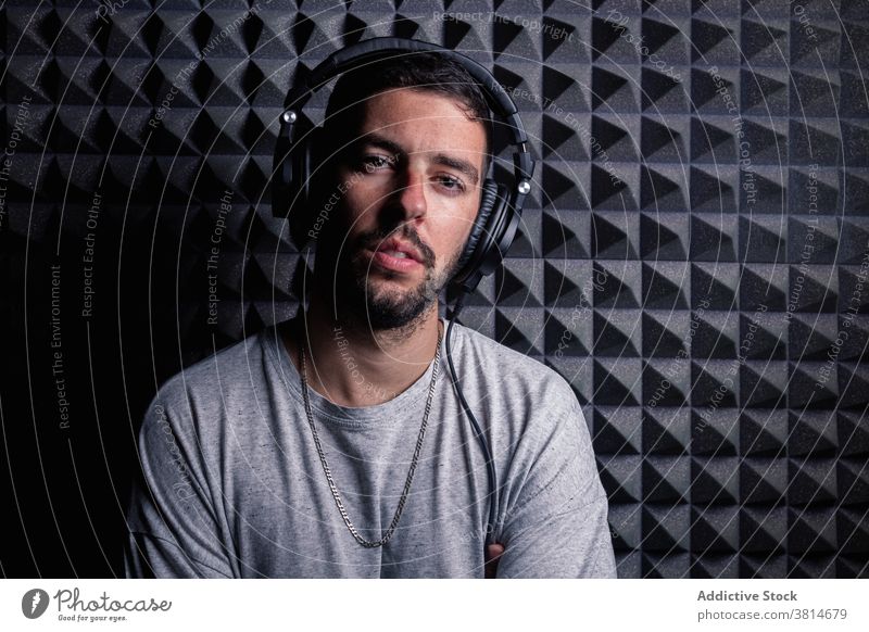 Confident man in headphones in recording studio sound proof music singer artist foam room male acoustic panel contemporary device modern confident equipment