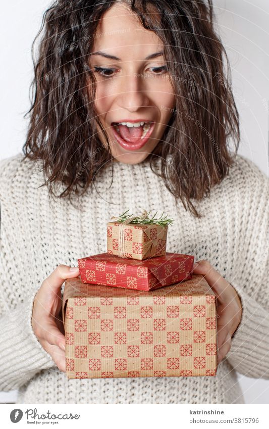 Surprised young woman holding Gifts in hands close up Young Gift box christmas happy emotioned white rustic sweater red ecru beige Wrapped Present casual