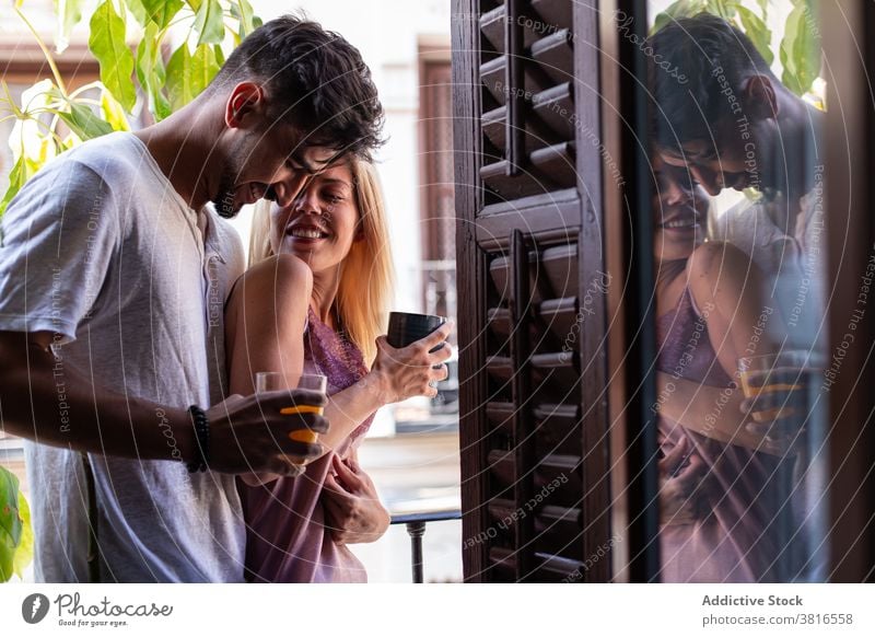 Loving couple hugging on balcony in morning love relationship embrace happy together drink affection young cheerful romantic girlfriend boyfriend lifestyle