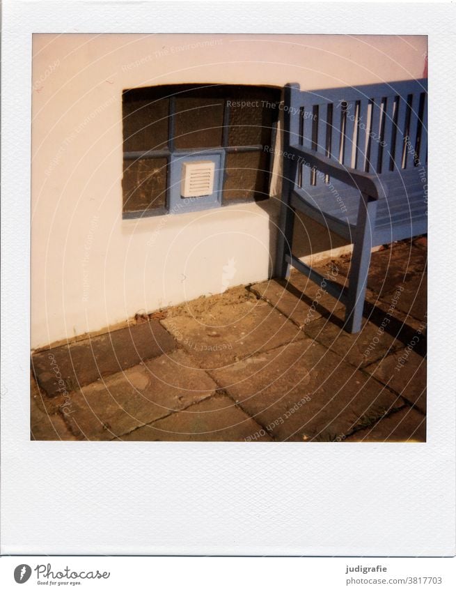 Seating next to basement window on Polaroid Bench Park bench Window Cellar window Wooden bench Blue Wall (building) walkway slabs Colour photo Relaxation Break