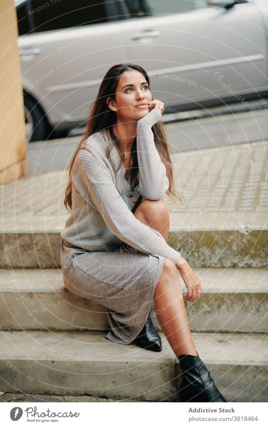 Stylish woman resting on stairs in city casual dress outfit street style tender relax apparel female stone trendy urban lean on hand gentle charming sit step