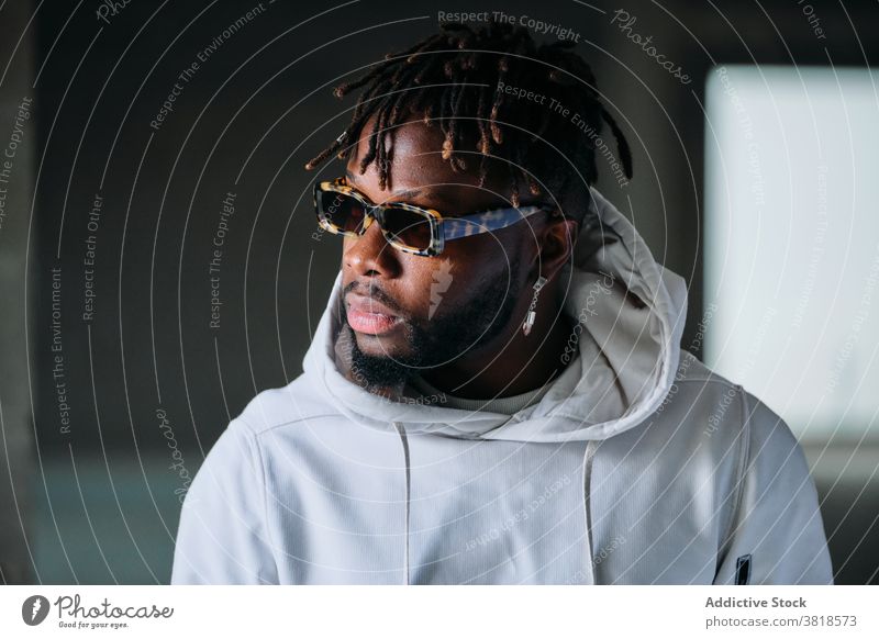 Black man in underground in city style male ethnic black african american dreadlocks hairstyle ring serious informal appearance sunglasses unemotional jewelry