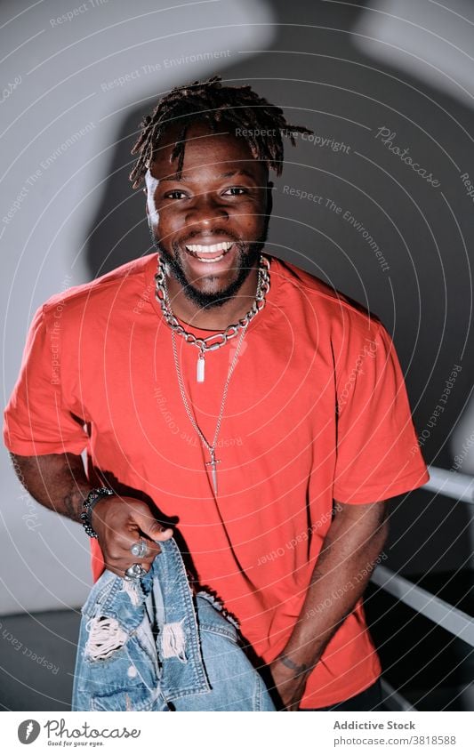 Smiling black man on metal staircase walk upstairs style outfit casual dreadlocks hairstyle male ethnic african american trendy positive smile cheerful step