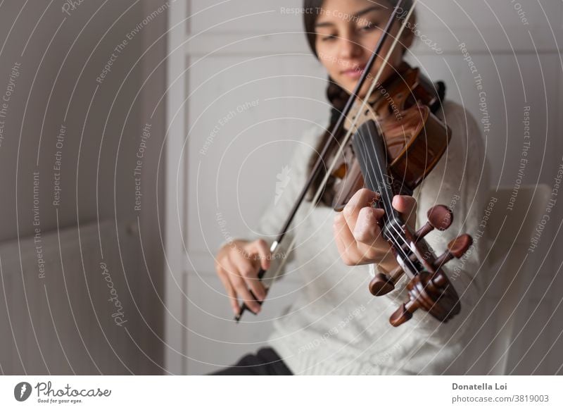 Young student violinist artist artistic bow brunette chord classic classical composition concert education elegant female fiddle fiddlestick girl hand indoors