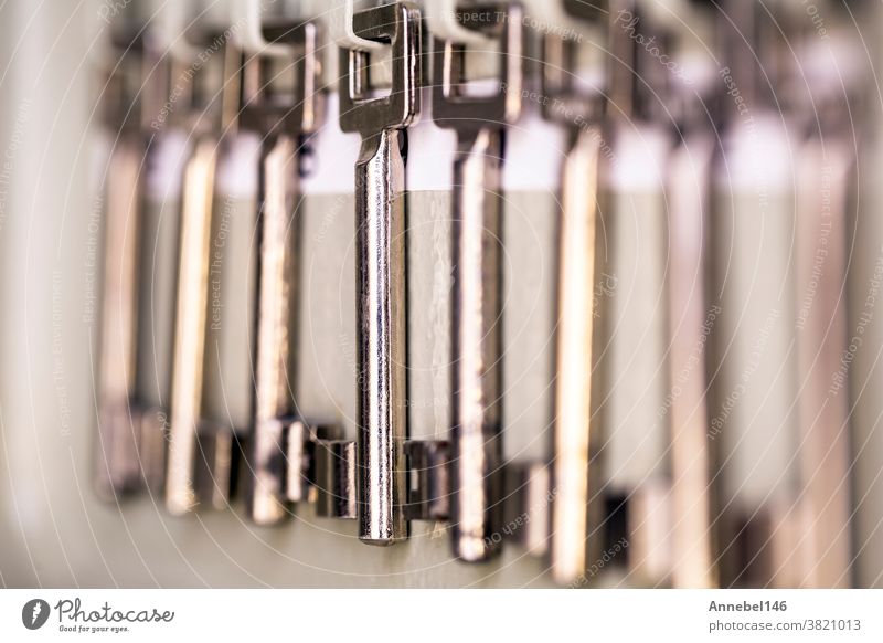 Row of old metal silver skeleton keys hanging in rack with numbers of the room. antique vintage keys steel lock security row metallic secure retro shiny