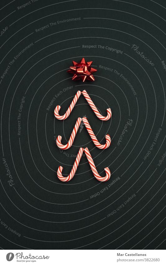 Christmas tree made with candy canes on a black background. Christmas concept. decoration christmas new year's eve star space copy christmas tree decorations