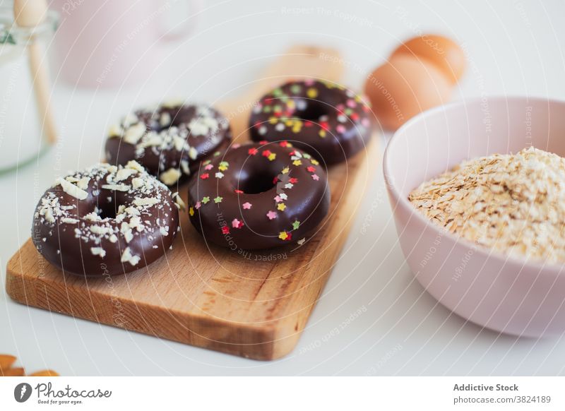 Donuts and ingredients for recipe on table donut doughnut pastry dessert sweet prepare food cook chocolate egg sprinkle almond delicious sugar culinary cuisine