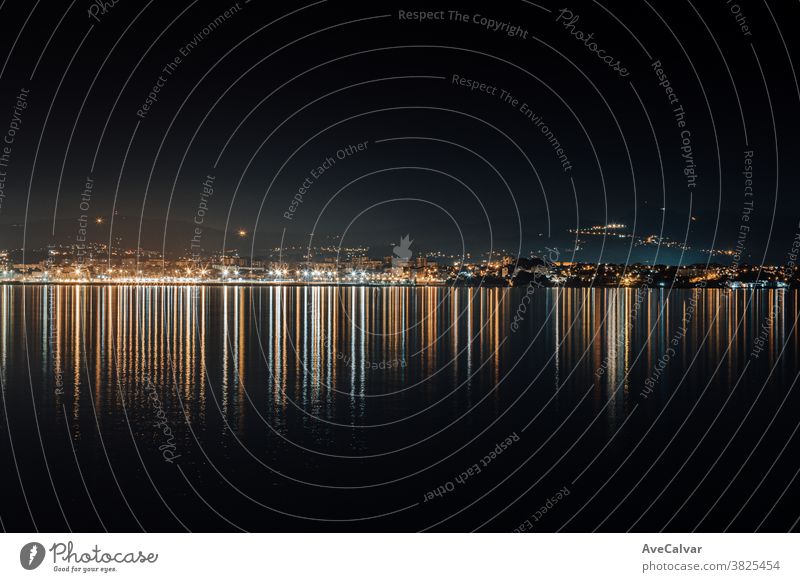 City skyline lights reflecting in the sea during the night evening smog harbor nightscape city water famous place business metropolitan architecture downtown