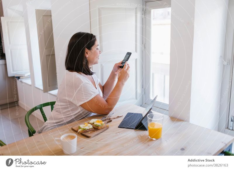 Woman taking a photo during breakfast time indoors home house girl woman avocado shopping kitchen coffee morning caucasian brunette table lifestyle casual