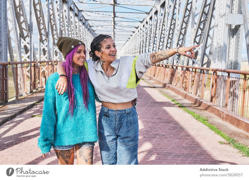 Stylish women in tattoos standing in bridge woman style trendy metal young urban glad cloth independent culture youth millennial feminine hipster weekend