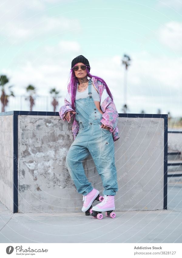 Stylish woman with pink hair in roller skates skate park hipster street style informal eccentric appearance female hobby having fun outfit trendy urban city