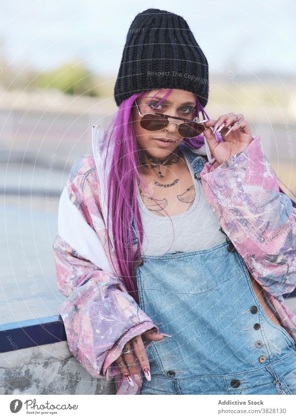 Woman in hip hop outfit in city millennial trendy fancy woman style sunglasses tattoo street style pink hair female cool young urban contemporary slim cloth