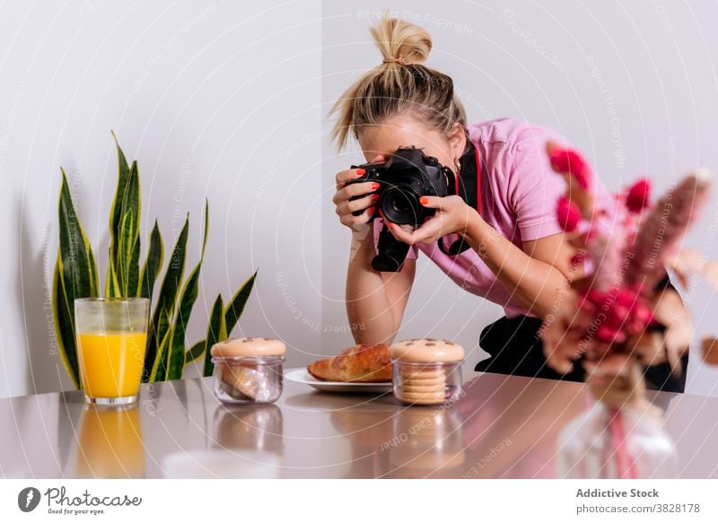 Woman taking photo of food in living room food photography photographer woman photo shoot professional take photo orange juice dessert female meal glass home