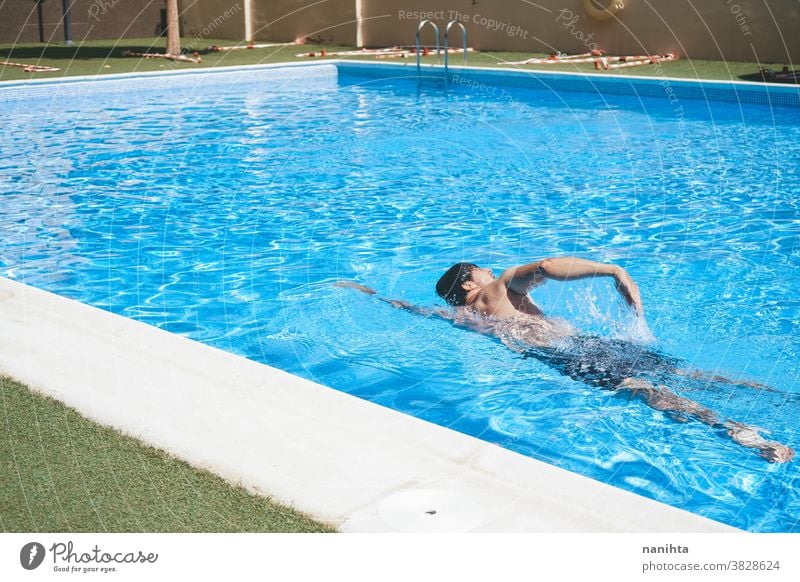 Young man enyoing the day at the swimming pool playful summer water attractive cool fresh holidays fun funny sport sportive swim trunks life lifestyle enjoy