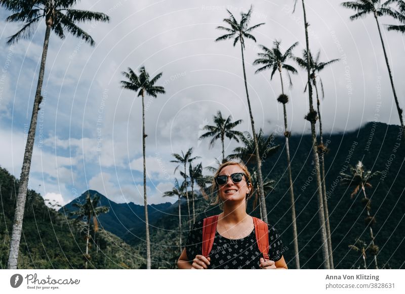 Hiking - Cocora Valley backpacker Palm tree palms Sunglasses Clouds blonde hair Woman Colombia photographed from bottom to top Sky Tall