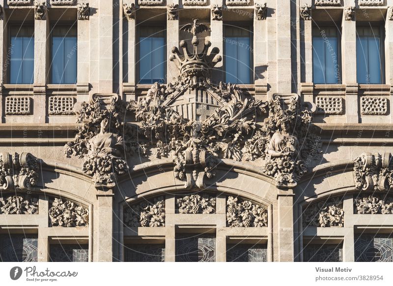 Coat of arms of the city of Barcelona sculpted in the facade of a modernist building emblem architecture glass symbol windows exterior structure construction