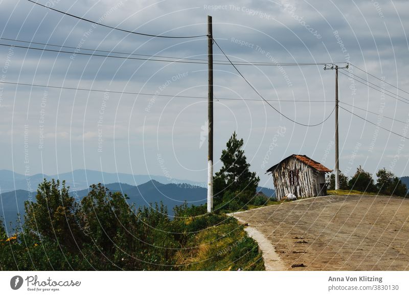 Panorama Street Wooden hut hillside Mountain Landscape Exterior shot Deserted Vacation & Travel Colour photo Sky Nature power line cloudy Clouds cloudy sky Peak