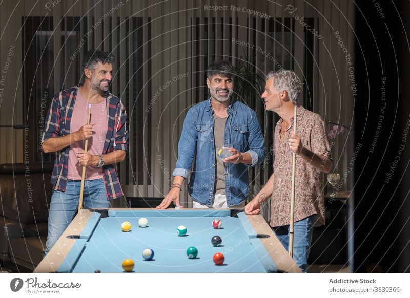 Cheerful men playing billiard while spending time together friendship weekend leisure hobby game chill enjoy smile beverage lifestyle cheerful drink relax