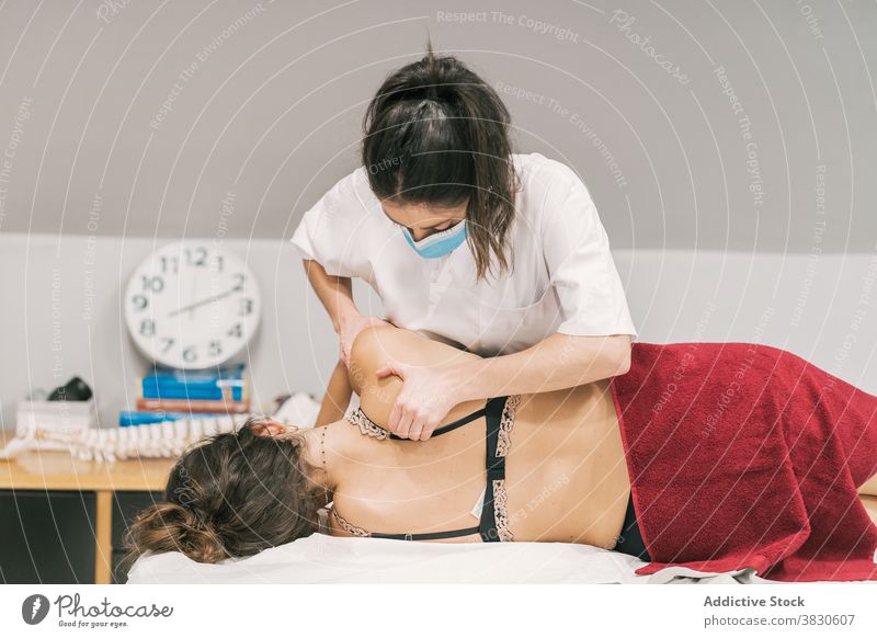 Masseuse doing therapeutic massage for patient rehabilitation back therapist therapy treat scapula clinic medicine professional care recovery help job visit