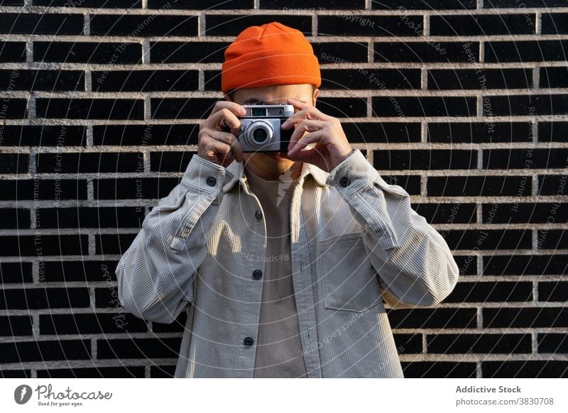 Man taking photos standing on brick wall man take photo photography device memory photo camera photographer gadget street moment hipster male equipment lens