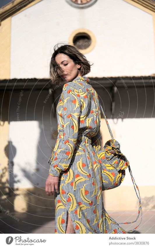 Gorgeous woman next to old building in sunlight gorgeous architecture pensive outfit glamour beautiful elegant thoughtful fashion female style bag construction