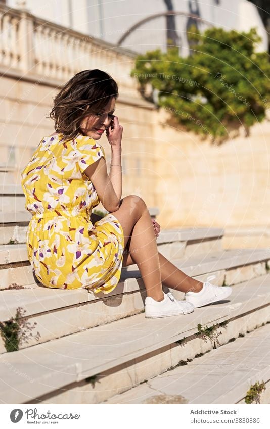 Thoughtful young tanned woman resting on stairway dreamy staircase allure summer style fashion chill relax female slim skinny thoughtful trendy carefree