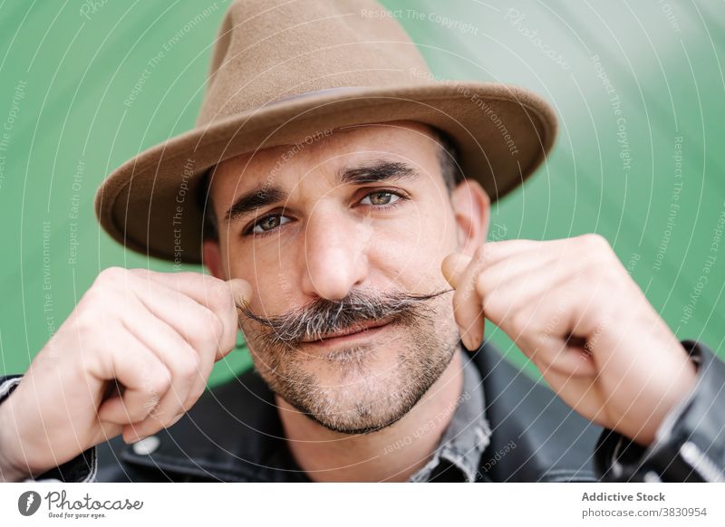 Serious man with mustache in hat curl leather jacket male pretend metrosexual optimist confident friendly trendy guy contemporary mature handsome charismatic