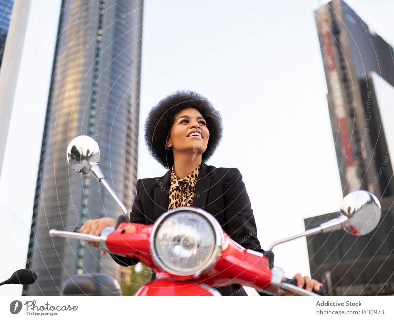 Happy black woman on red scooter motorbike vintage smile confident delight concentrate happy classic style elegant female appearance individuality vehicle