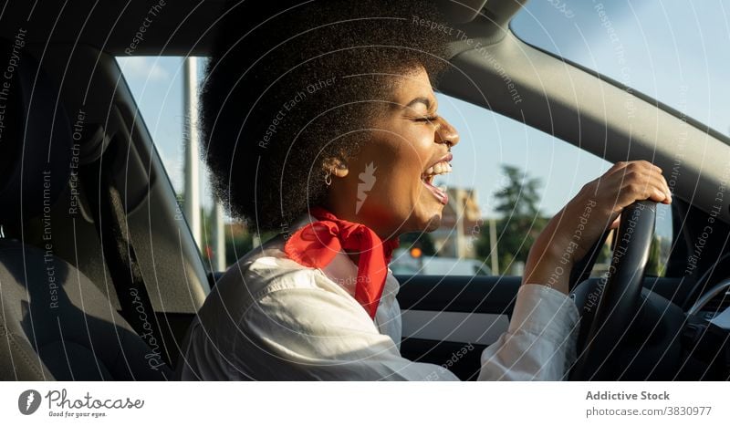Happy black woman driving car and smiling brightly excited drive eyes closed happy laugh glad joy optimist female cheerful relax automobile driver transport