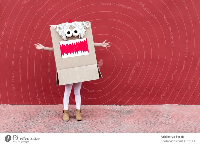 Child in funny carnival costume on street monster carton box child playful vivid handmade creative holiday party festive celebrate kid event fantasy masquerade