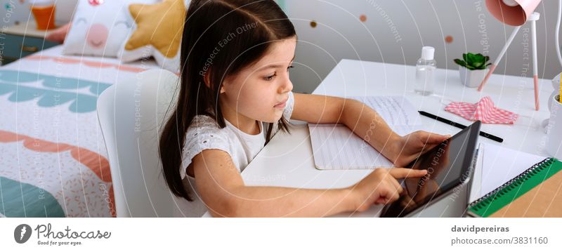 Girl studying at home with tablet and mask on table girl school at home home schooling coronavirus covid-19 digital wisdom social distancing banner header web