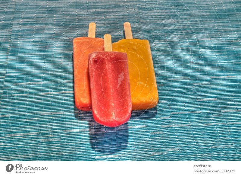 Fruit popsicles on an aqua blue background in summer Popsicle watermelon popsicle tropical fruit popsicle mango popsicle lime popsicle frozen desert raspberries