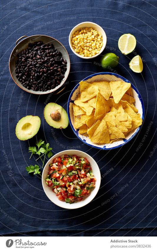 Ingredients for mexican cuisine food chilaquiles dish tortilla breakfast black beans nachos cilantro sauce fried meal chips fresh salsa homemade cheese onion