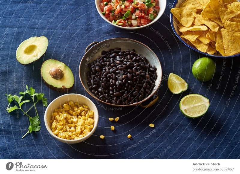 Ingredients for mexican cuisine food chilaquiles dish tortilla breakfast black beans nachos cilantro sauce fried meal chips fresh salsa homemade cheese onion