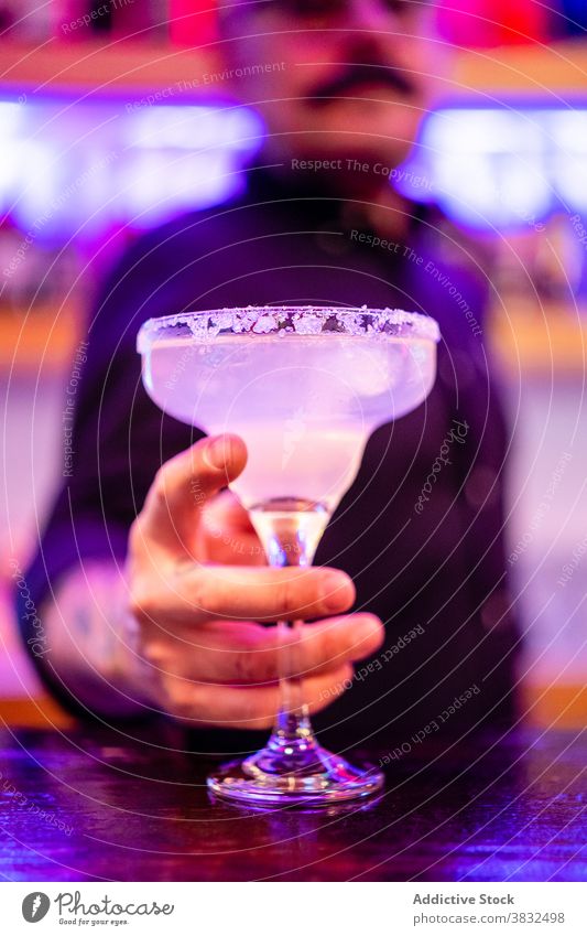 Anonymous mature bartender holding cocktail in pub man barkeeper confident cool cold drink style alcohol male service various beverage trendy modern serve