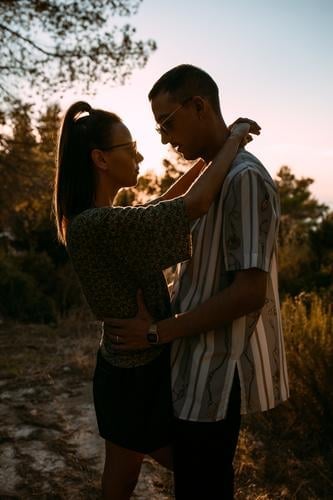 Loving couple hugging in nature at sunset love gentle evening style together relationship sundown sky romantic boyfriend affection casual embrace relax tender