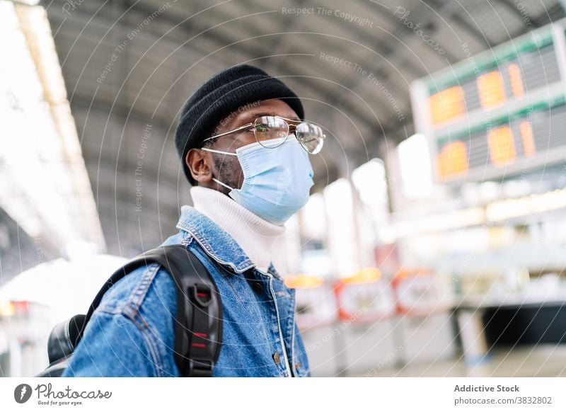 Black man in mask on train station railway station travel tourist medical coronavirus new normal male ethnic black african american traveler passenger journey