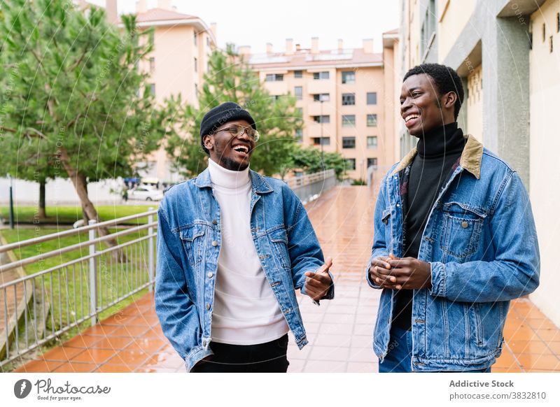 Delighted black men laughing in city having fun friend joke together style denim street ethnic african american happy cheerful friendship joy modern trendy