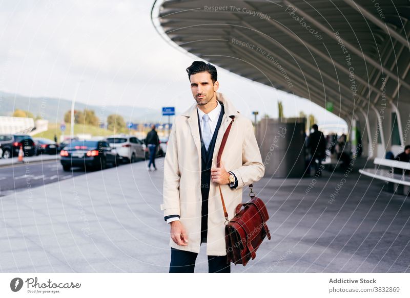 Pensive man looking at camera near airport standing trendy watch street style businessman concentrate male thoughtful daytime ethnic pensive modern young