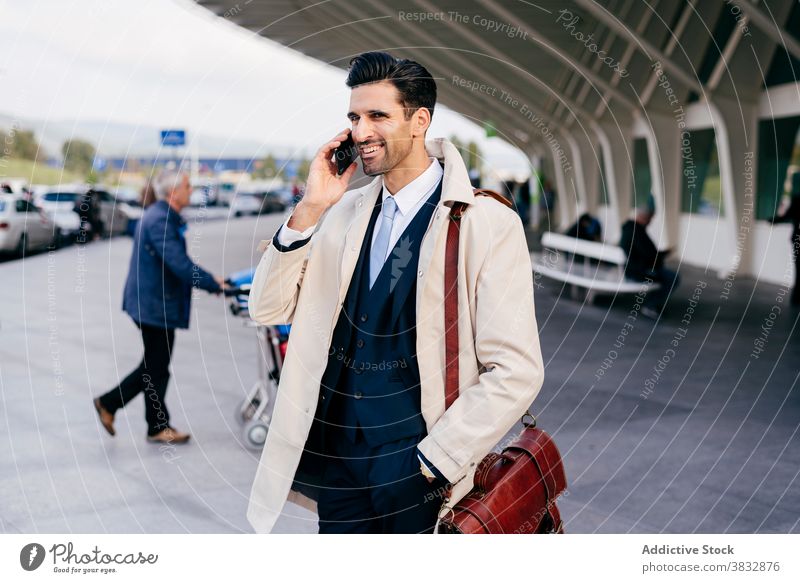 Pensive man speaking on phone near airport trendy street style businessman concentrate male thoughtful daytime ethnic pensive modern talk young dark hair bag
