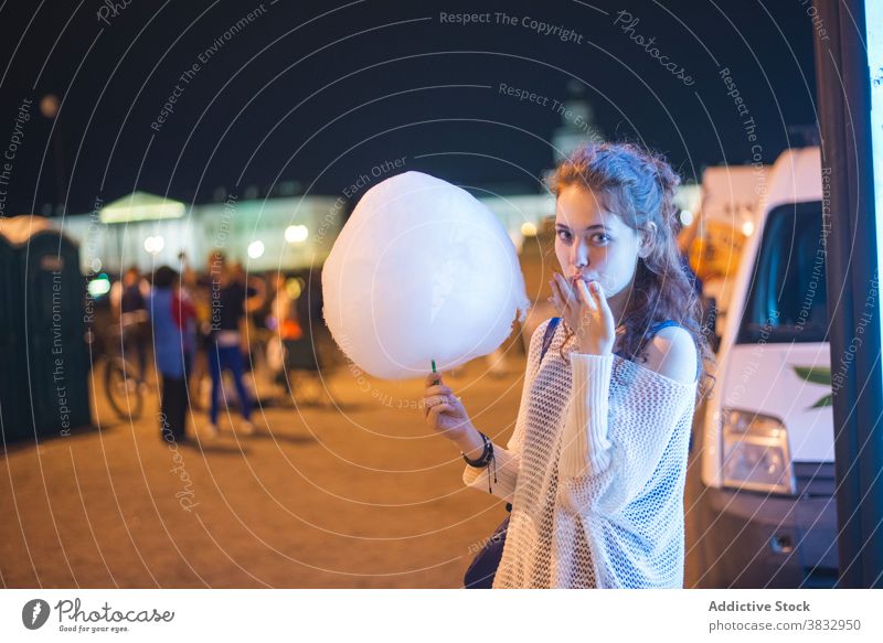 Young woman enjoying cotton candy in night city eat urban happy sweet twilight millennial female student young cheerful lifestyle saint petersburg russia