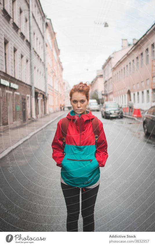 Young red haired woman standing on road in city redhead urban young wind serious millennial street curly hair long hair female saint petersburg russia travel