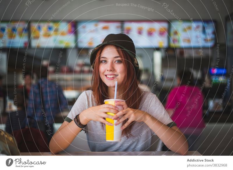 Cheerful young woman enjoying takeaway drink in cafe cup cheerful hipster happy disposable beverage teen female trendy cafeteria modern lifestyle smile