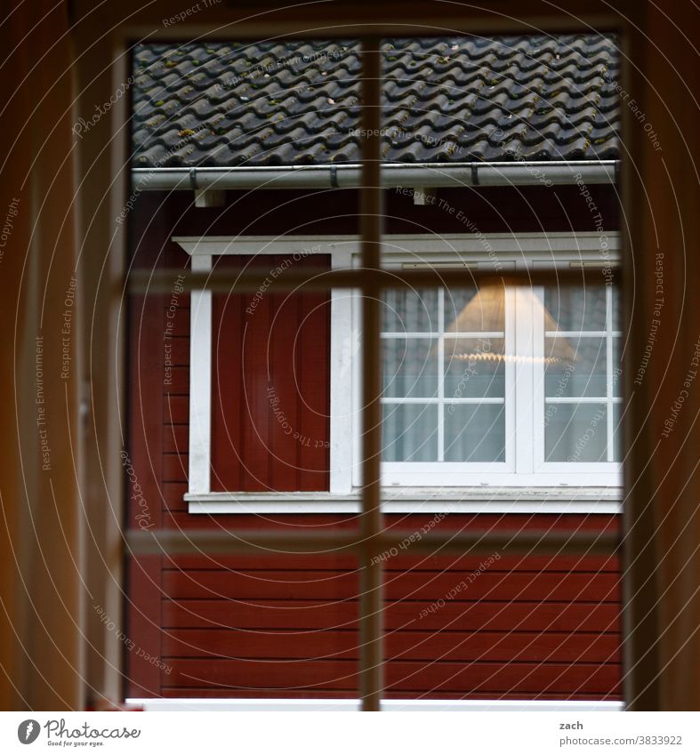 Behind the windows House (Residential Structure) Hut Wooden house Wooden hut Fishermans hut fifty-two board Window pane Reflection Facade Red Lamp Illuminate